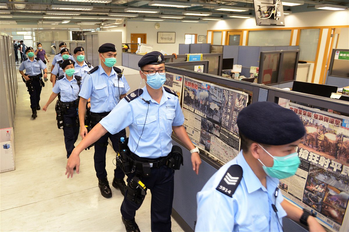<i>Apple Daily/AP</i><br/>Police officers raid the Apple Daily headquarters in Hong Kong on August 10