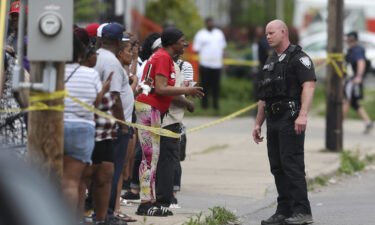 Police speak to bystanders after the shooting at a supermarket on May 14