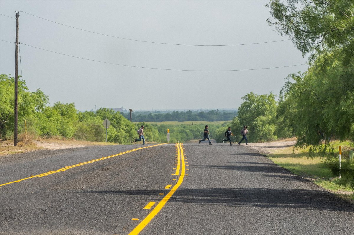 <i>Brandon Bell/Getty Images</i><br/>A group of migrants run across a street after illegally crossing into the U.S. from Mexico on May 3 in La Joya