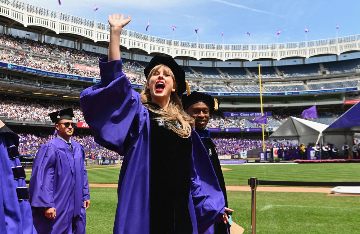 <i>Angela Weiss/AFP/Getty Images</i><br/>Taylor Swift waves at graduating students during New York University's commencement ceremony for the class of 2022.