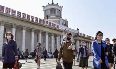People wearing protective face masks walk amid concerns over Covid-19  in front of Pyongyang Station in Pyongyang