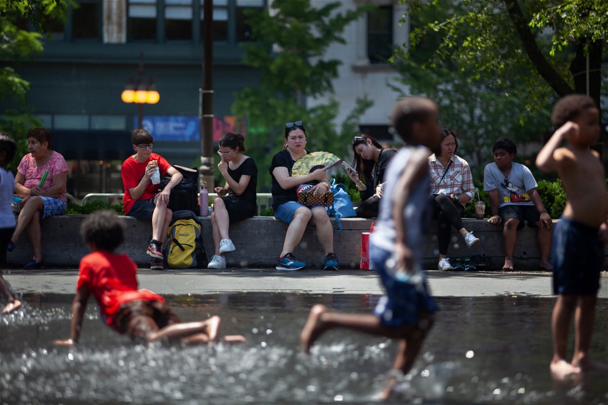 Children play outside in downtown Chicago on June 14. Temperatures and heat indices have soared to triple digits this week in the Midwest and Southeast.