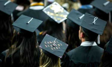 The cap of a University of Iowa graduates candidate is decorated with writing reading "Cancel student debt" during a commencement ceremony for the College of Liberal Arts and Sciences