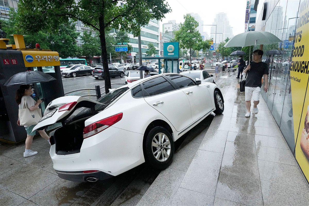 <i>Ahn Young-joon/AP</i><br/>A vehicle is damaged on the sidewalk after floating in heavy rainfall in Seoul