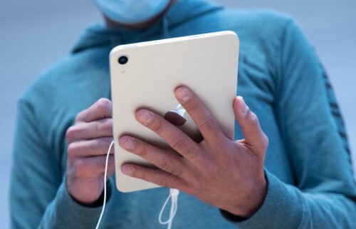 A customer uses an Apple iPad Mini tablet for sale at a store in New York in September 2021. Apple is directing users of most of its devices to update their software.