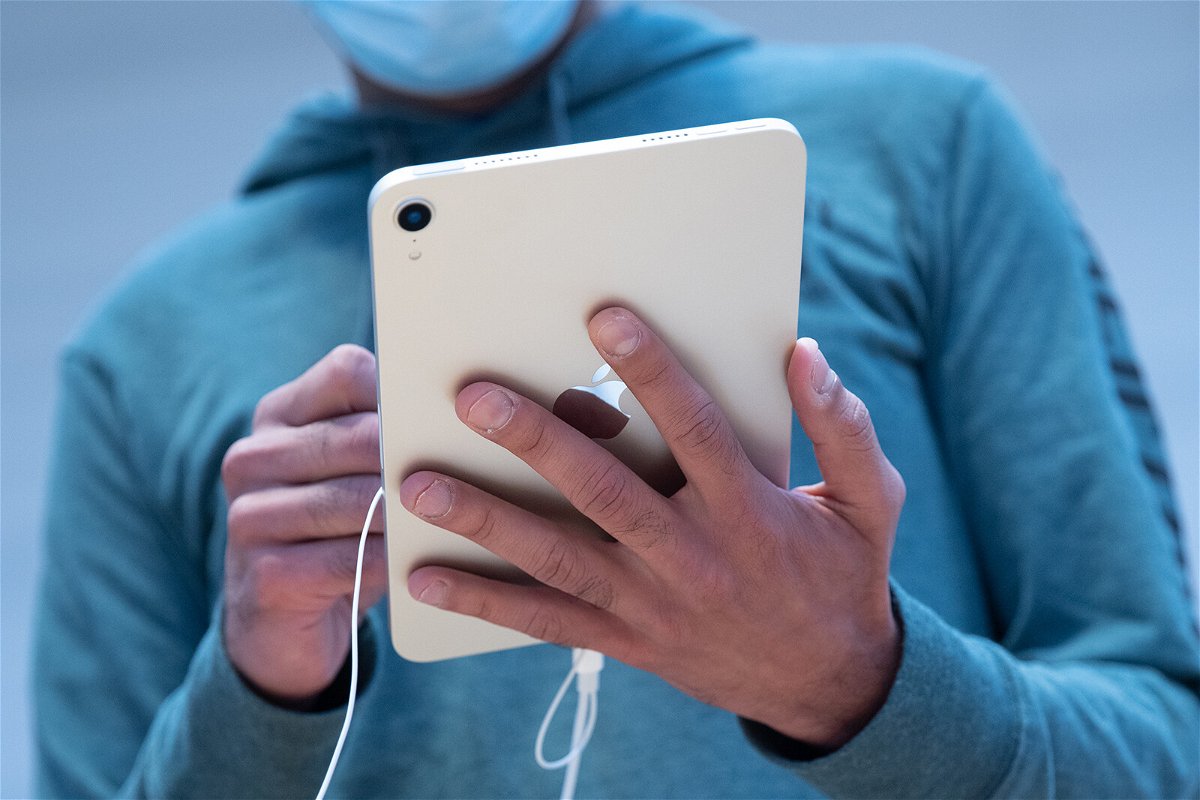 <i>Jeenah Moon/Bloomberg/Getty Images</i><br/>A customer uses an Apple iPad Mini tablet for sale at a store in New York in September 2021. Apple is directing users of most of its devices to update their software.