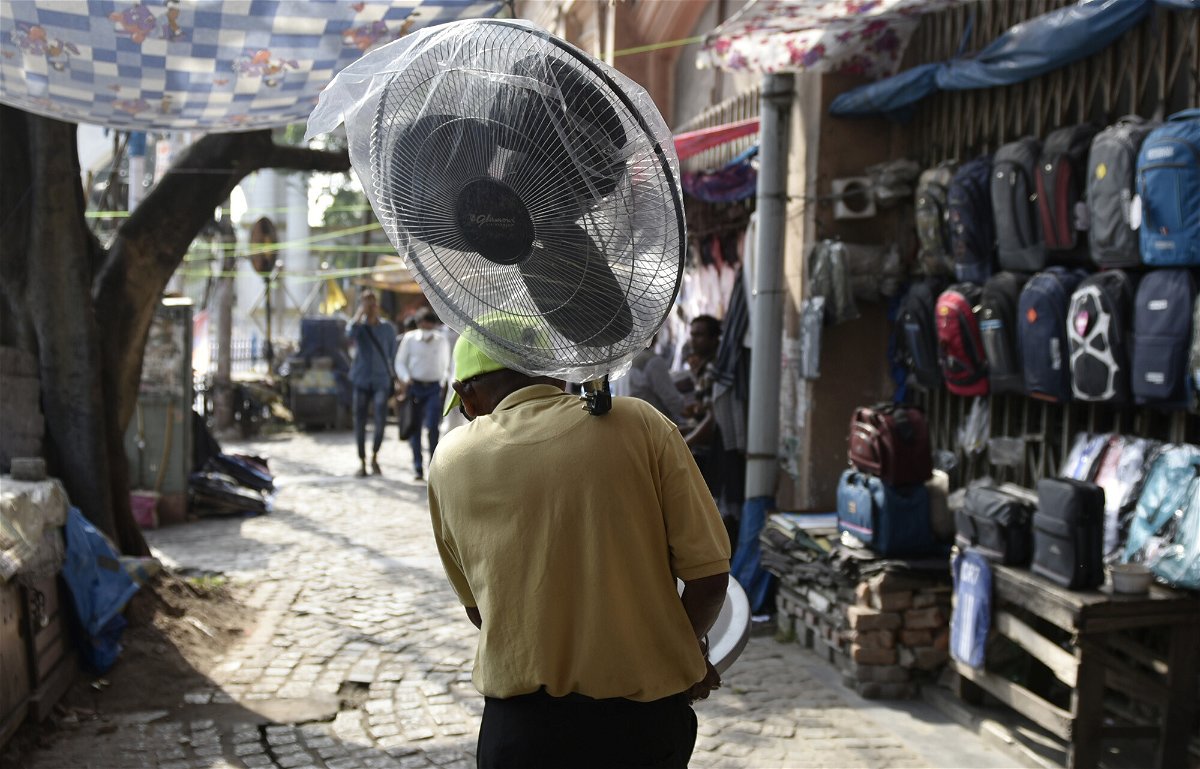 <i>Indranil Aditya/NurPhoto/Reuters</i><br/>A man carries a pedestrial fan amid a heat wave in Kolkata
