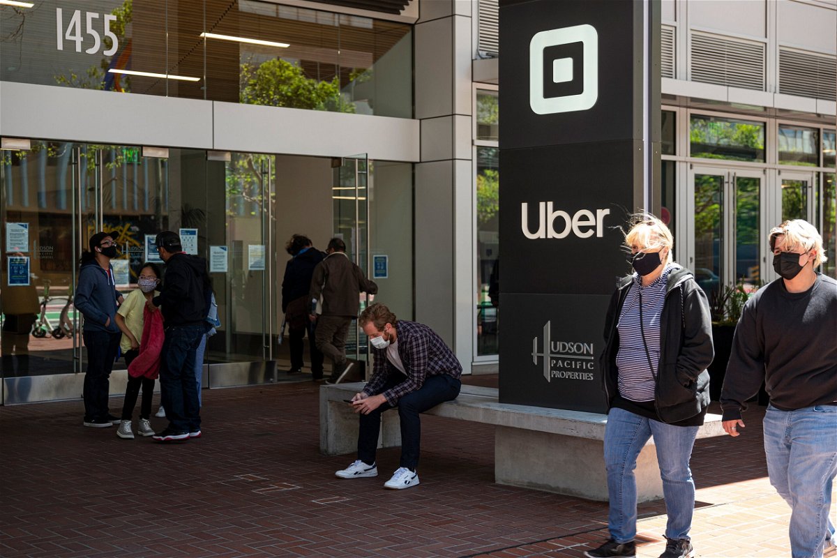 People wear protective masks in front of Uber's headquarters in San Francisco