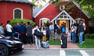 Migrants gather with their belongings outside St. Andrews Episcopal Church on September 14