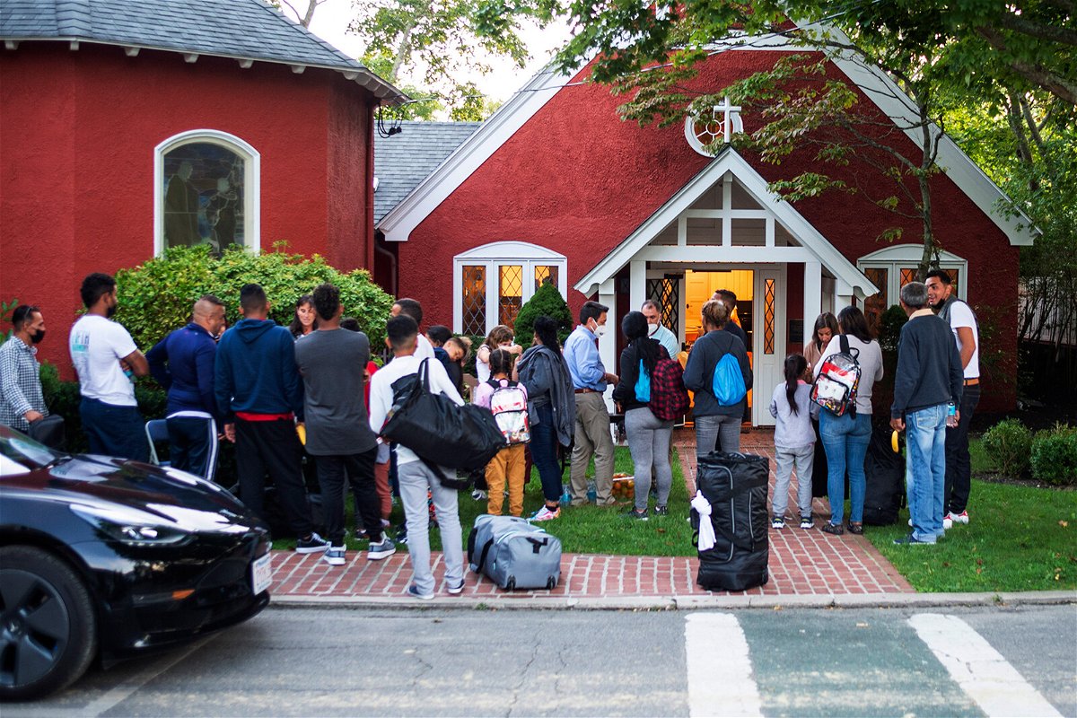 <i>Ray Ewing/AP</i><br/>Migrants gather with their belongings outside St. Andrews Episcopal Church on September 14