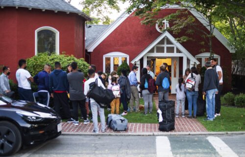 The migrants flown from Texas gather outside a church on Martha's Vineyard on September 14. The man who recruited migrants for flights to Martha's Vineyard says he feels betrayed.