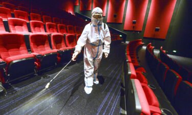 China has banned residents from leaving Xinjiang over a Covid-19 outbreak. A worker is seen here wearing personal protective equipment disinfecting a cinema on August 9 in Urumqi