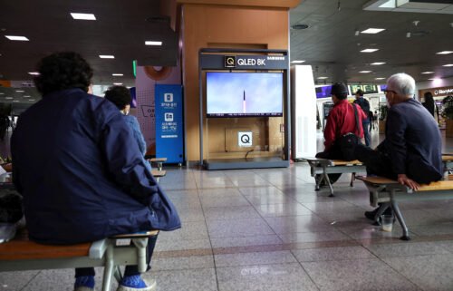 North Korea fired a ballistic missile without warning over Japan on October 4 for the first time in five years. People are seen here watching a TV broadcasting a news report on the missile