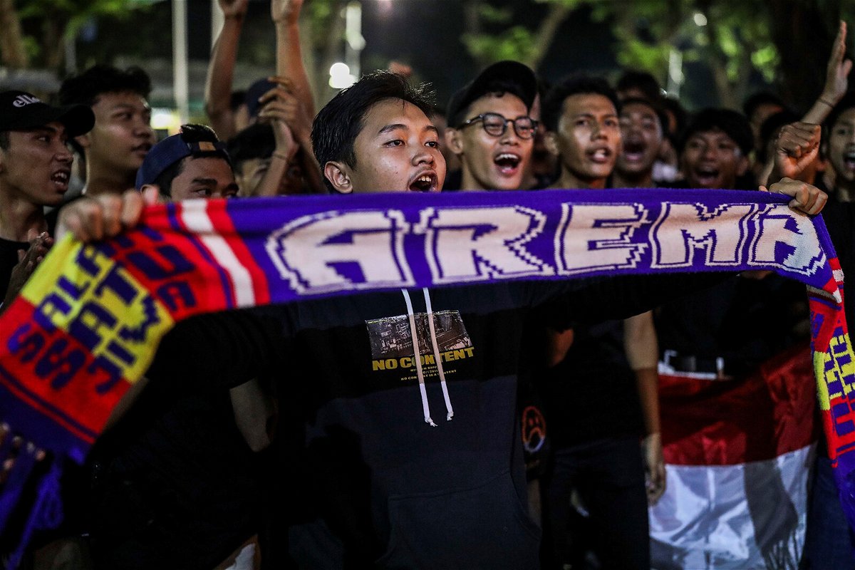 <i>Garry Lotulung/NURPHO/Associated Press</i><br/>Soccer fans chant slogans during a candle light vigil for Arema FC Supporters who became victims of Saturday's soccer riots