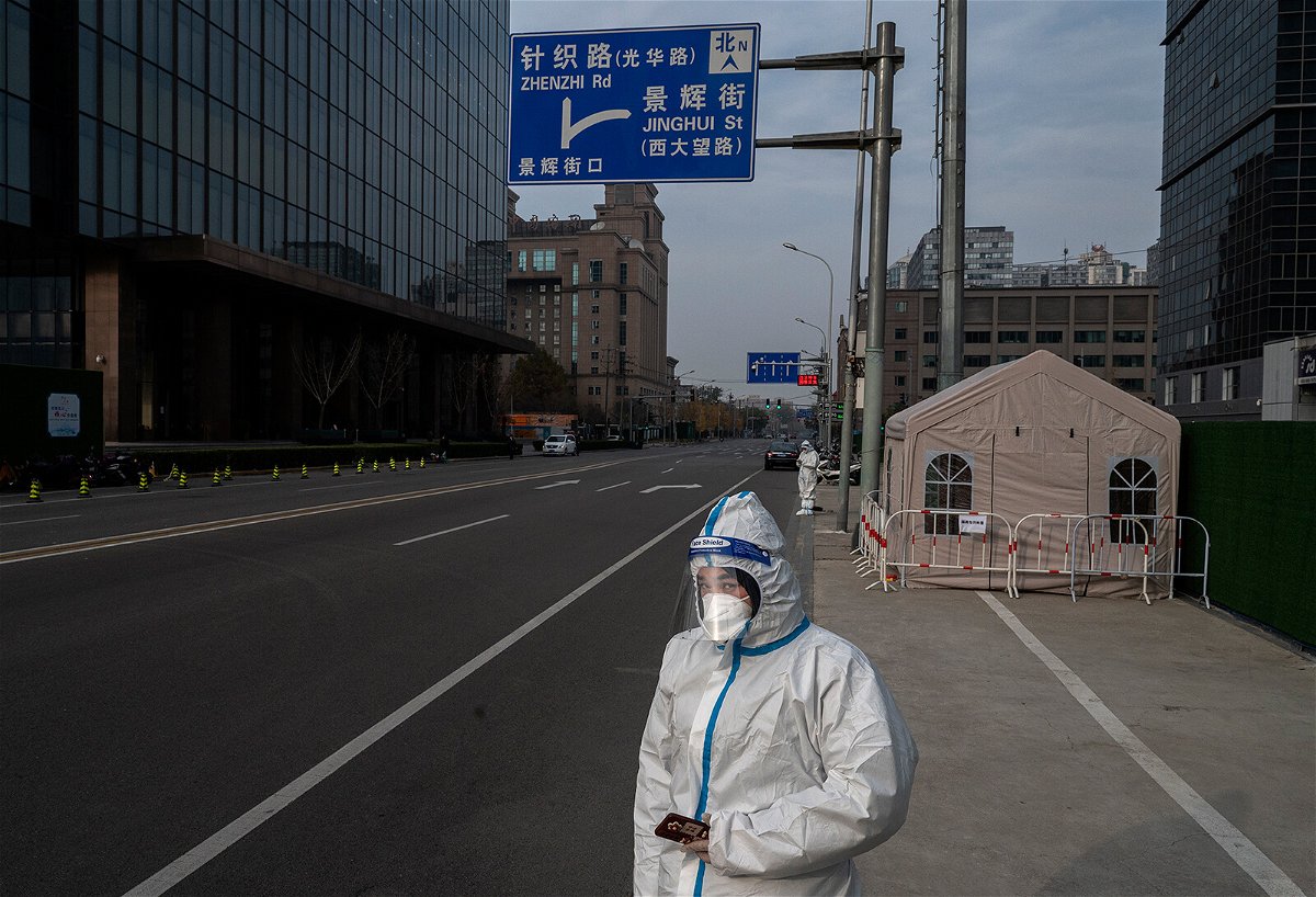 <i>Kevin Frayer/Getty Images</i><br/>An epidemic control worker wears protective clothing to protect against the spread of COVID-19 as she stands in a nearly empty street in the Central Business District on November 23
