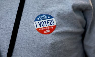 A voter wears an "I Voted" sticker after voting on August 23