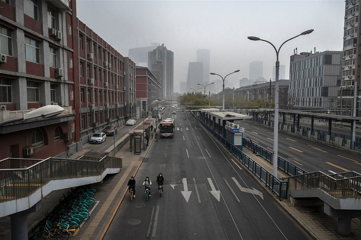 <i>Kevin Frayer/Getty Images</i><br/>People ride bikes on an empty street near Beijing's central business district on November 24.