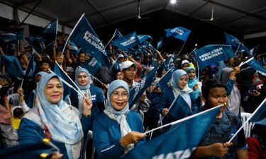 Supporters of the Perikatan Nasional party wave flags at a campaign rally in Kuala Lumpur.