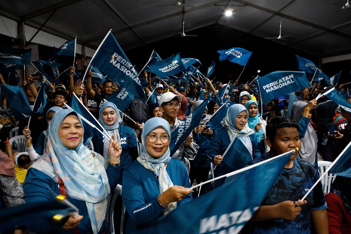 <i>Samsul Said/Bloomberg/Getty Images</i><br/>Supporters of the Perikatan Nasional party wave flags at a campaign rally in Kuala Lumpur.