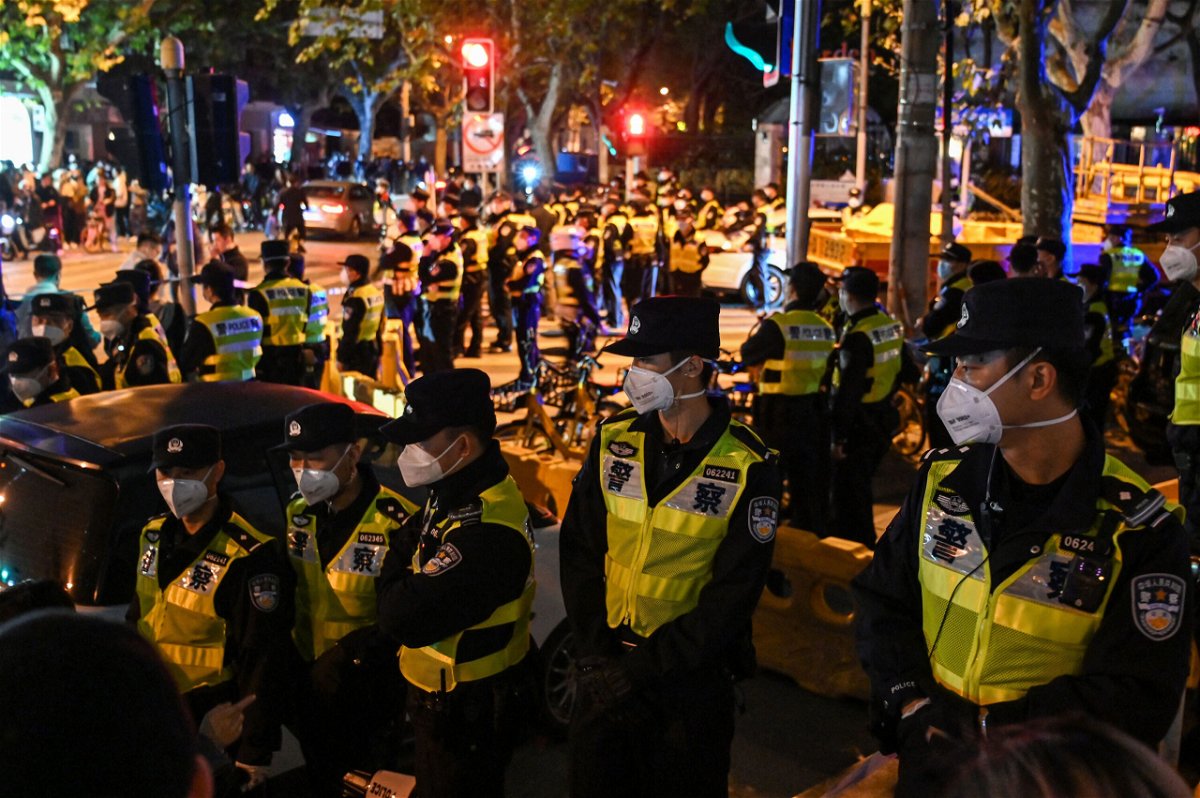<i>Hector Retamal/AFP/Getty Images</i><br/>Police officers block Shanghai's Urumqi Road on Sunday.