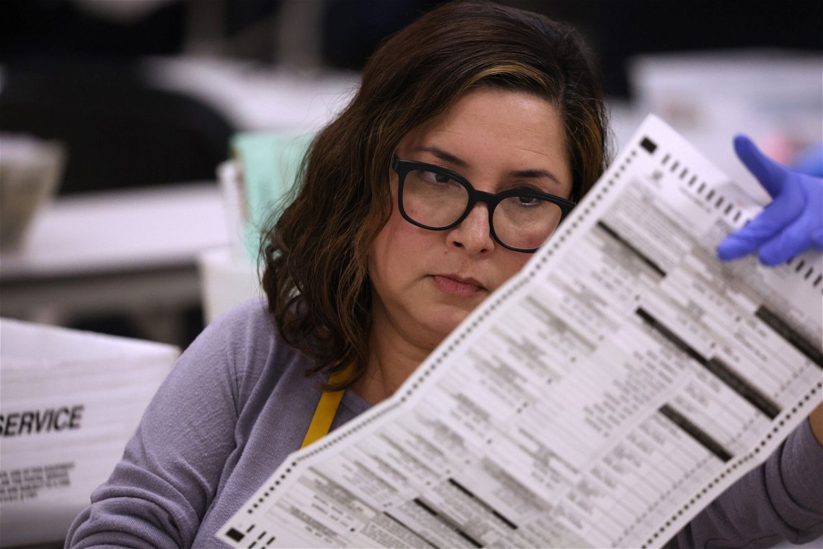 <i>Justin Sullivan/Getty Images</i><br/>An elections worker inspects a mail-in ballot on November 06