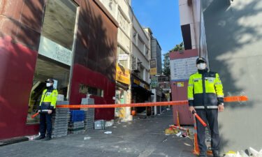 Police stand guard next to the alley where a fatal crowd crush took place during Halloween celebrations in the district of Itaewon in Seoul.