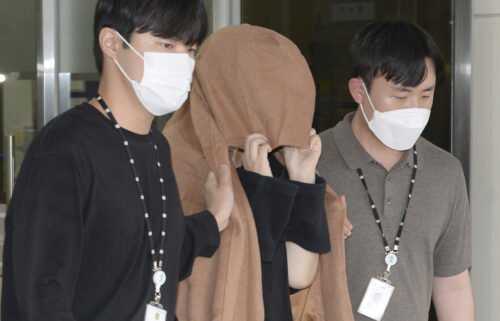 The mother appears in a New Zealand court over the alleged suitcase murders. She's seen here leaving a police station in Ulsan