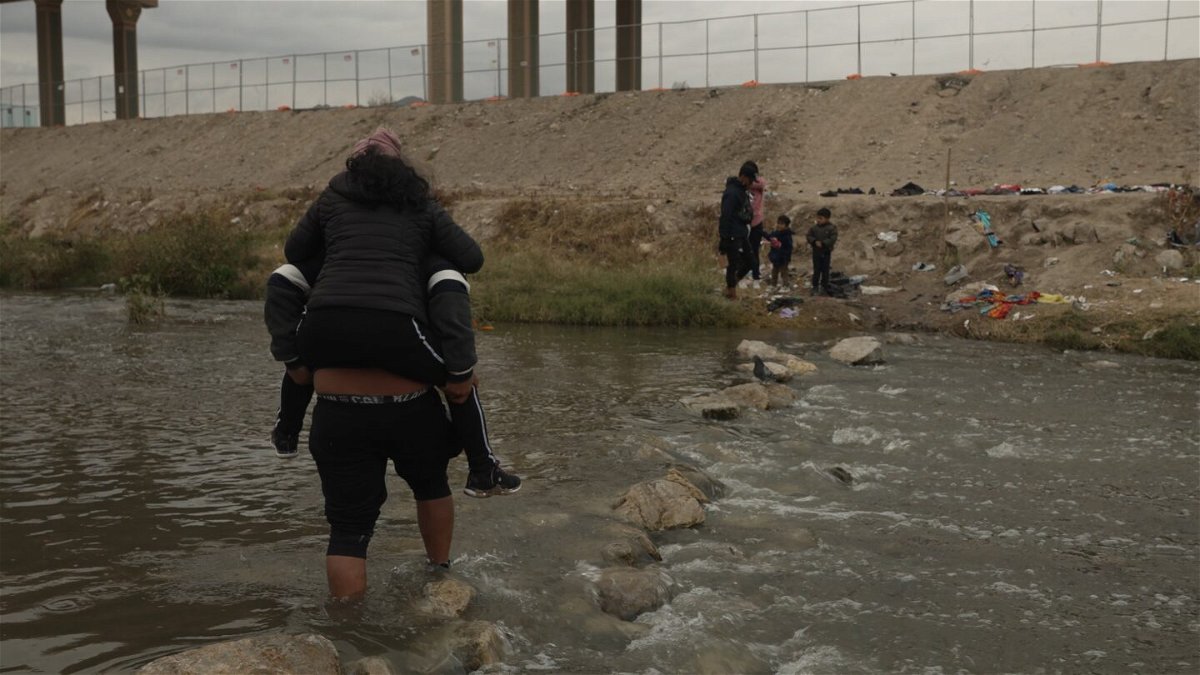 <i>David von Blohn/CNN</i><br/>A group of migrants cross the Rio Grande into the US from Ciudad Juarez at the Mexico-US border.