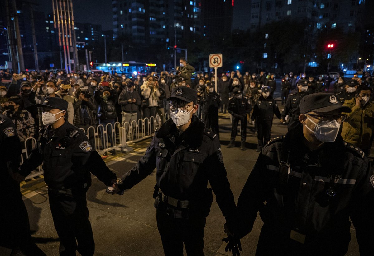 <i>Kevin Frayer/Getty Images</i><br/>Chinese police are using cellphone data to track down protesters. Police are seen here forming a cordon during a protest in Beijing on November 27.