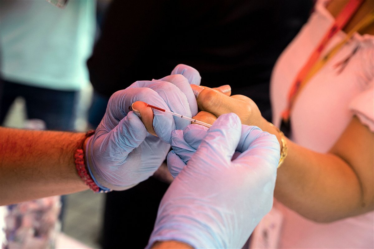<i>Yuri Cortez/AFP/Getty Images</i><br/>An experimental HIV vaccine has been found to induce broadly neutralizing antibodies among a small group of volunteers in a Phase 1 study. A health worker takes a blood sample from a woman to perform a rapid HIV test in Venezuela in 2021.