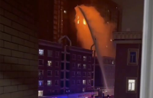 Firefighters spray water on a fire at a residential building in Urumqi