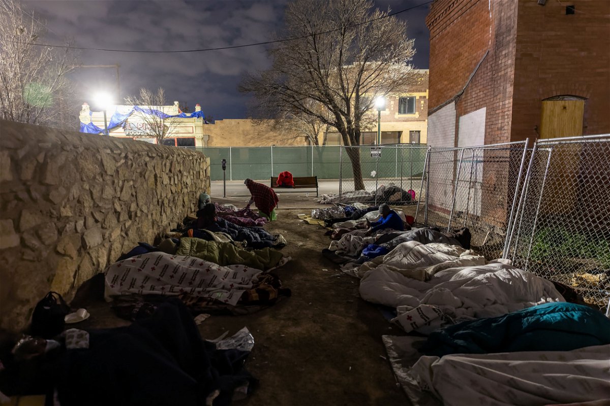 <i>John Moore/Getty Images</i><br/>Immigrants sleep in the cold outside a bus station on December 18