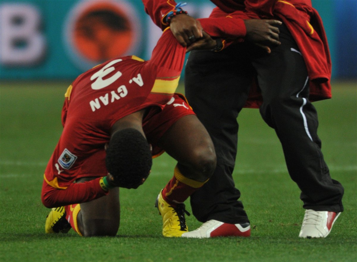 <i>ROBERTO SCHMIDT/AFP/AFP via Getty Images</i><br/>Asamoah Gyan (left) is consoled following the penalty shootout defeat in 2010.