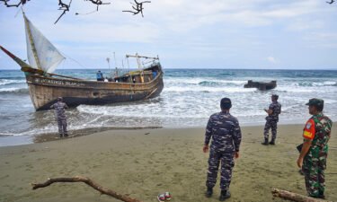 Indonesian military personnel inspect a wooden boat used to carry Rohingya refugees after it landed on Indra Patra beach in Ladong village