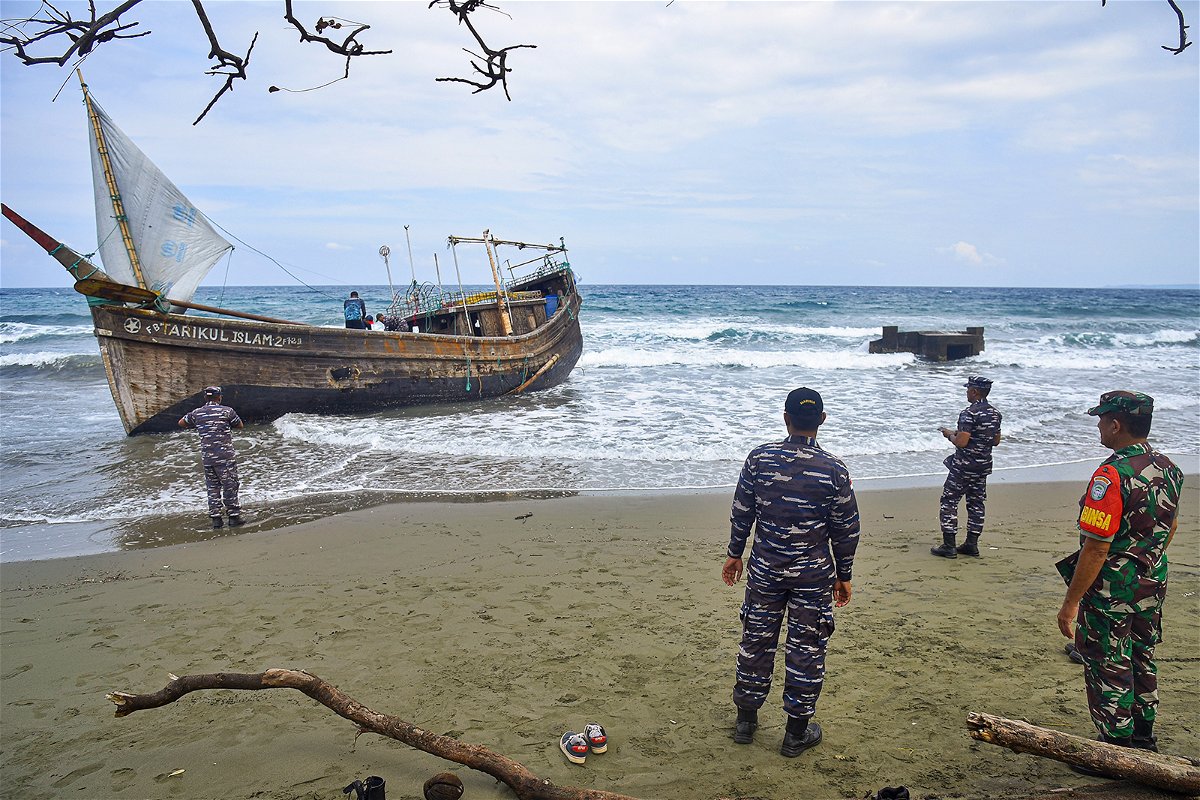 <i>Rahmat Mirza/AP</i><br/>Indonesian military personnel inspect a wooden boat used to carry Rohingya refugees after it landed on Indra Patra beach in Ladong village