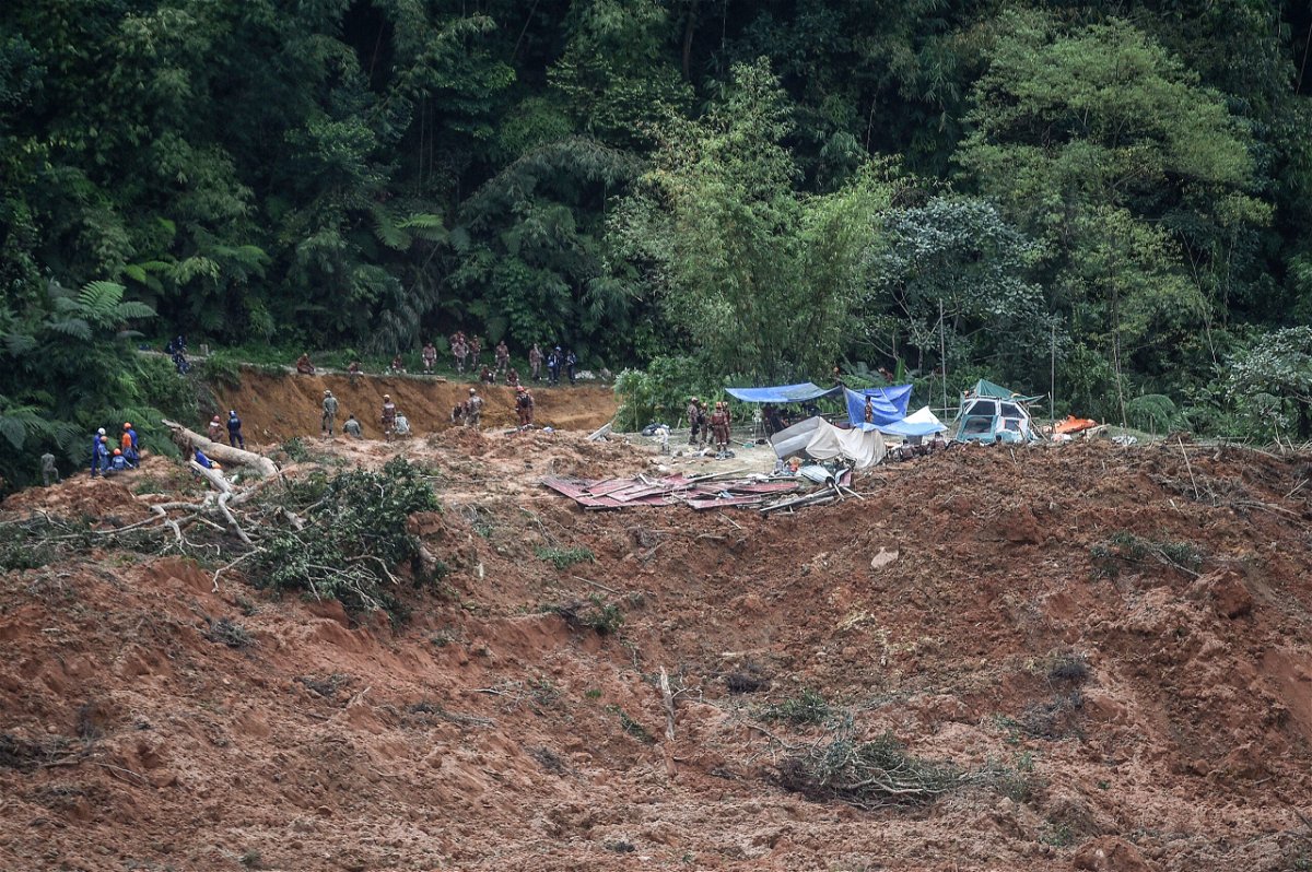 <i>Arif Kartono/AFP/Getty Images</i><br/>Malaysian officials inspect the site damaged after the landslide.