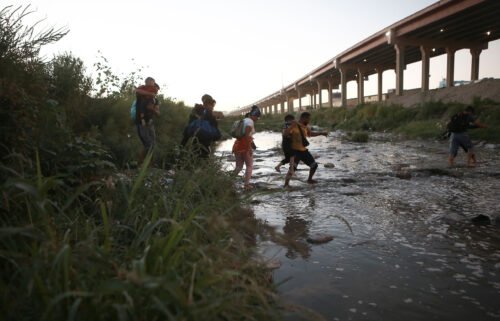 The Biden administration is considering a proposal that would bar migrants from seeking asylum at the US-Mexico border if they could have received refuge in another country. Venezuelan migrants are pictured walking across the Rio Bravo on October 13.