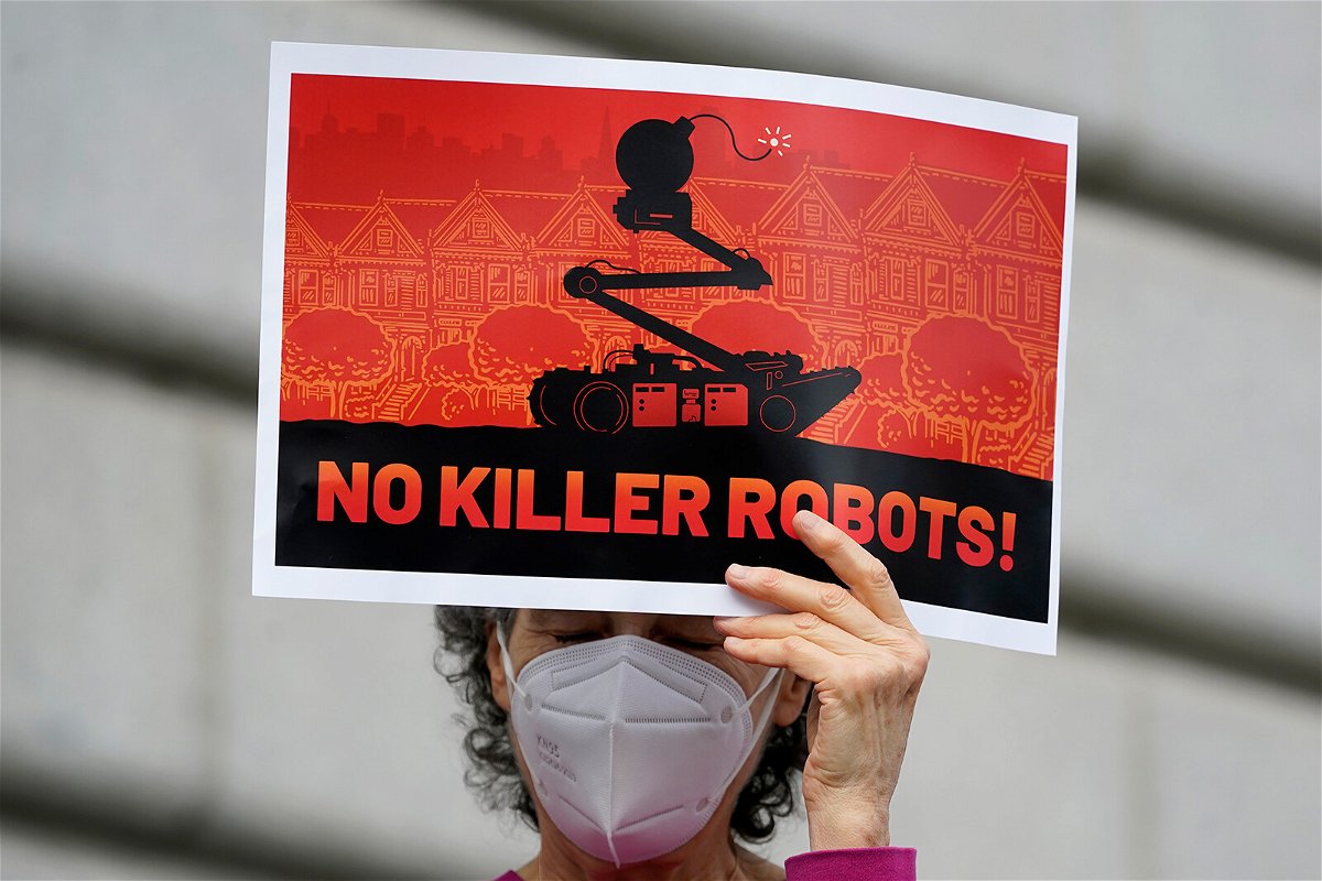 <i>Jeff Chiu/AP</i><br/>A woman demonstrates against about the use of robots by the San Francisco Police Department outside of City Hall Monday. San Francisco officials reverse course after public outcry against the policy.