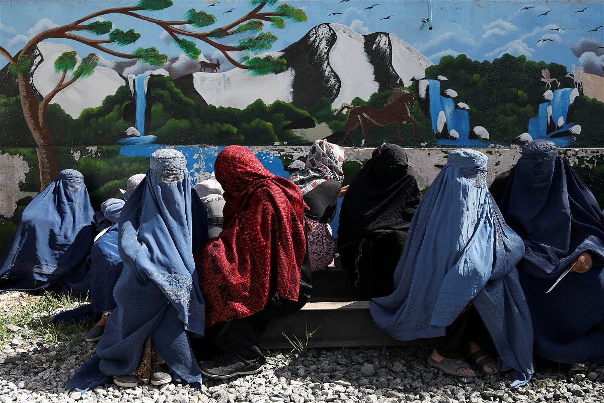 <i>Ali Khara/Reuters</i><br/>Afghan women wait to receive a food package being distributed by a Saudi Arabia humanitarian aid group at a distribution center in Kabul