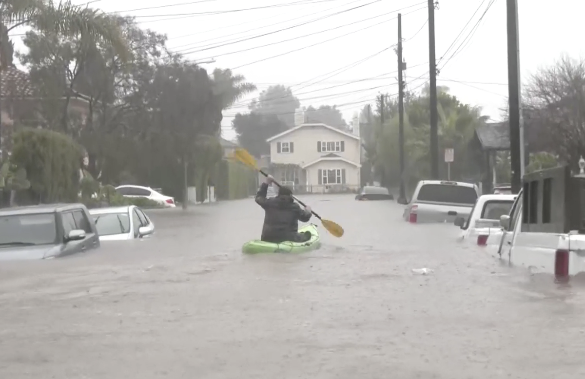 California Storm Man goes kayaking along flooded street in Santa