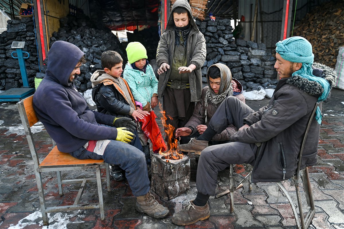<i>Wakil Kohsar/AFP/Getty Images</i><br/>Afghans gather around a bonfire after snowfall in Kabul on January 23.