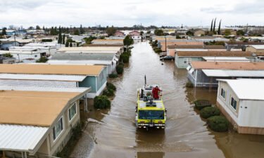 This aerial view shows rescue crews assisting stranded residents in a flooded neighborhood in Merced