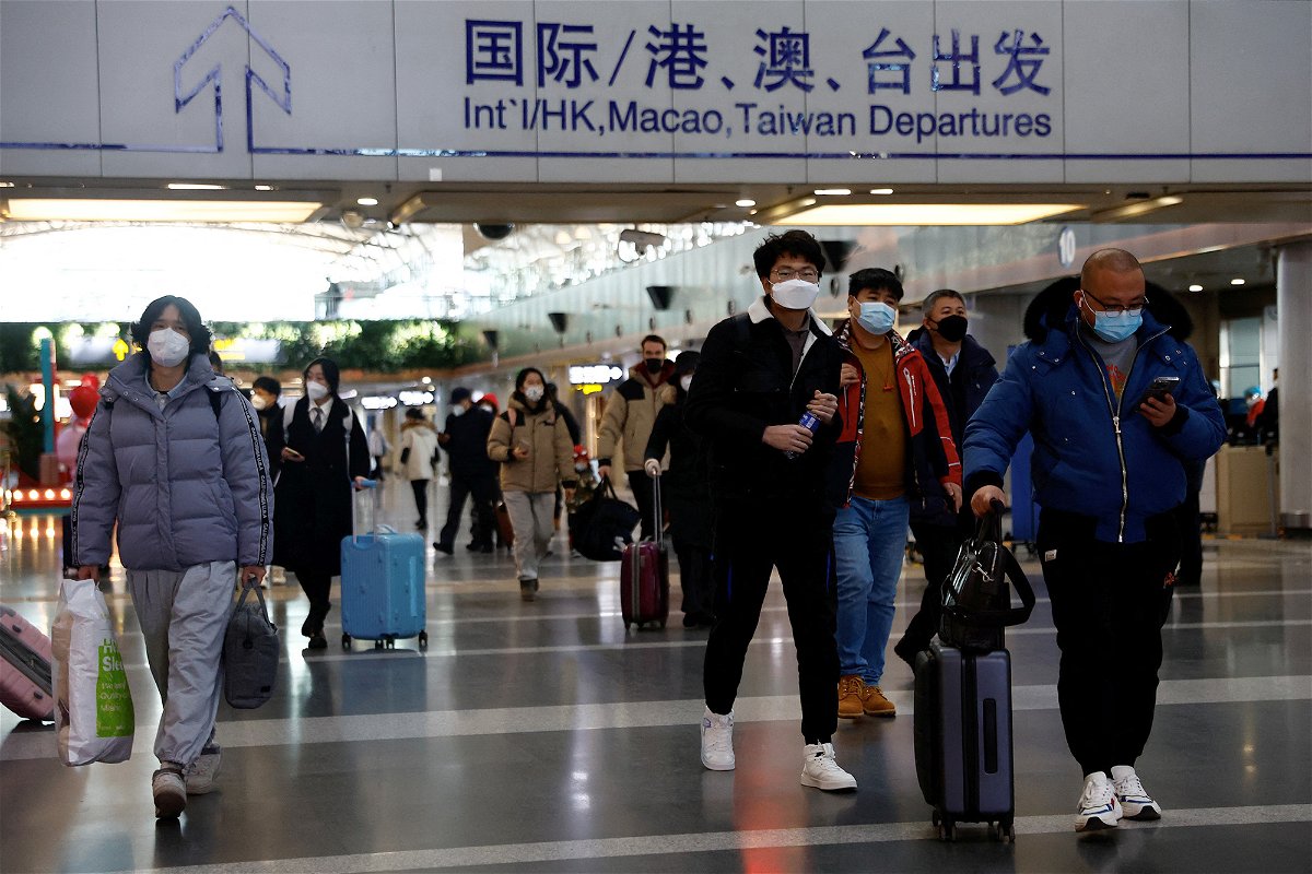 <i>Tingshu Wang/Reuters</i><br/>Travellers walk with their luggage at Beijing Capital International Airport in Beijing