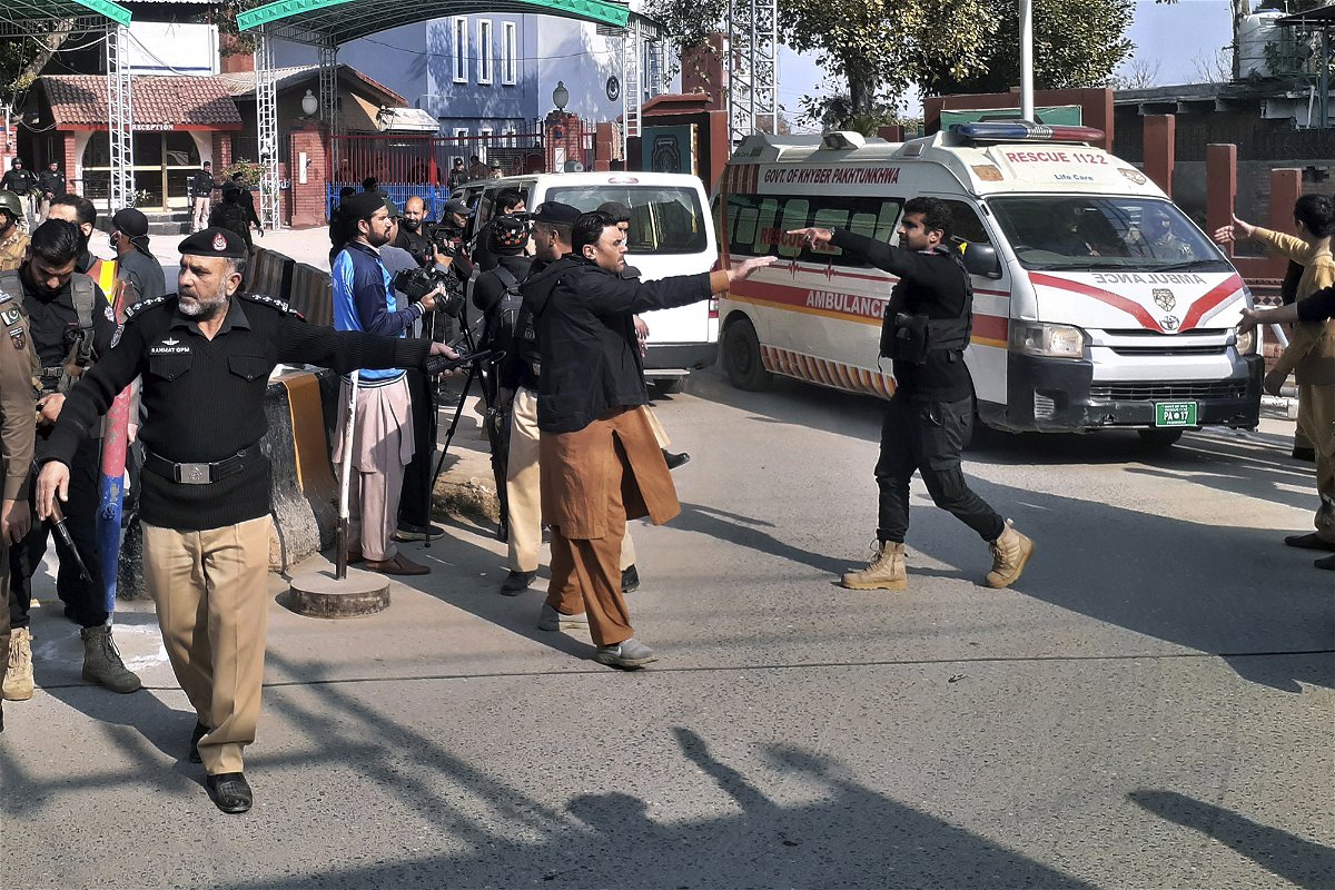 <i>Muhammad Sajjad/AP</i><br/>Police officers clear the route for ambulances carrying wounded people from the scene in Peshawar