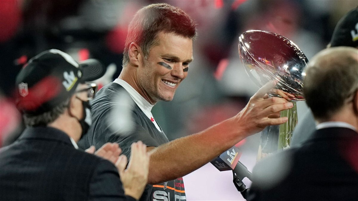 <i>David J. Phillip/AP</i><br/>Brady looks at the Vince Lombardi trophy after defeating the Kansas City Chiefs in the Super Bowl on February 7