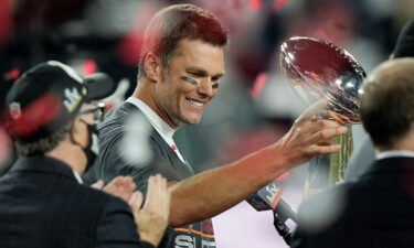 Brady looks at the Vince Lombardi trophy after defeating the Kansas City Chiefs in the Super Bowl on February 7