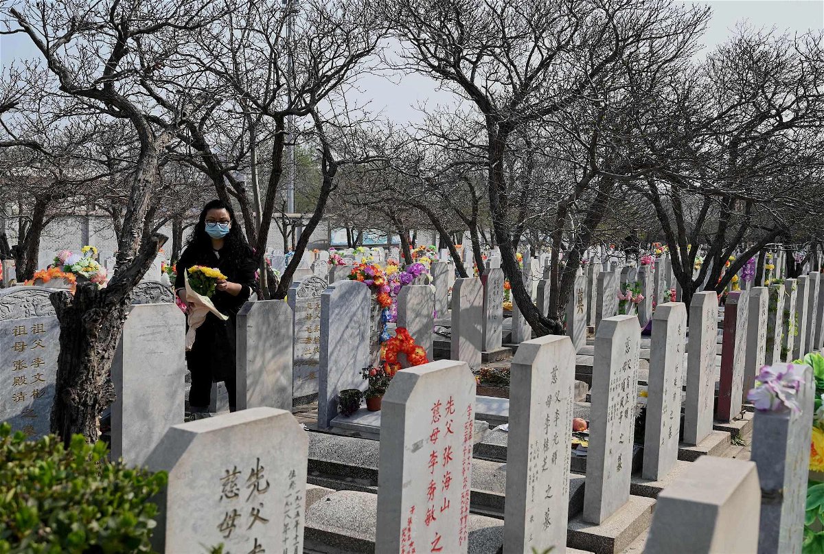 <i>Noel Celis/AFP/Getty Images/FILE</i><br/>Beijing's population has declined for the first time in 19 years. A woman carries flowers as she visits the Babaoshan People's Cemetery in Beijing
