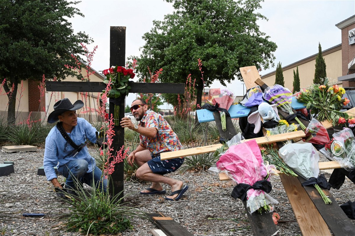 <i>Jeremy Lock/Reuters</i><br/>Muralist Roberto Marquez and his friend Israel Gil erect a memorial to honor the victims on the mall shooting.