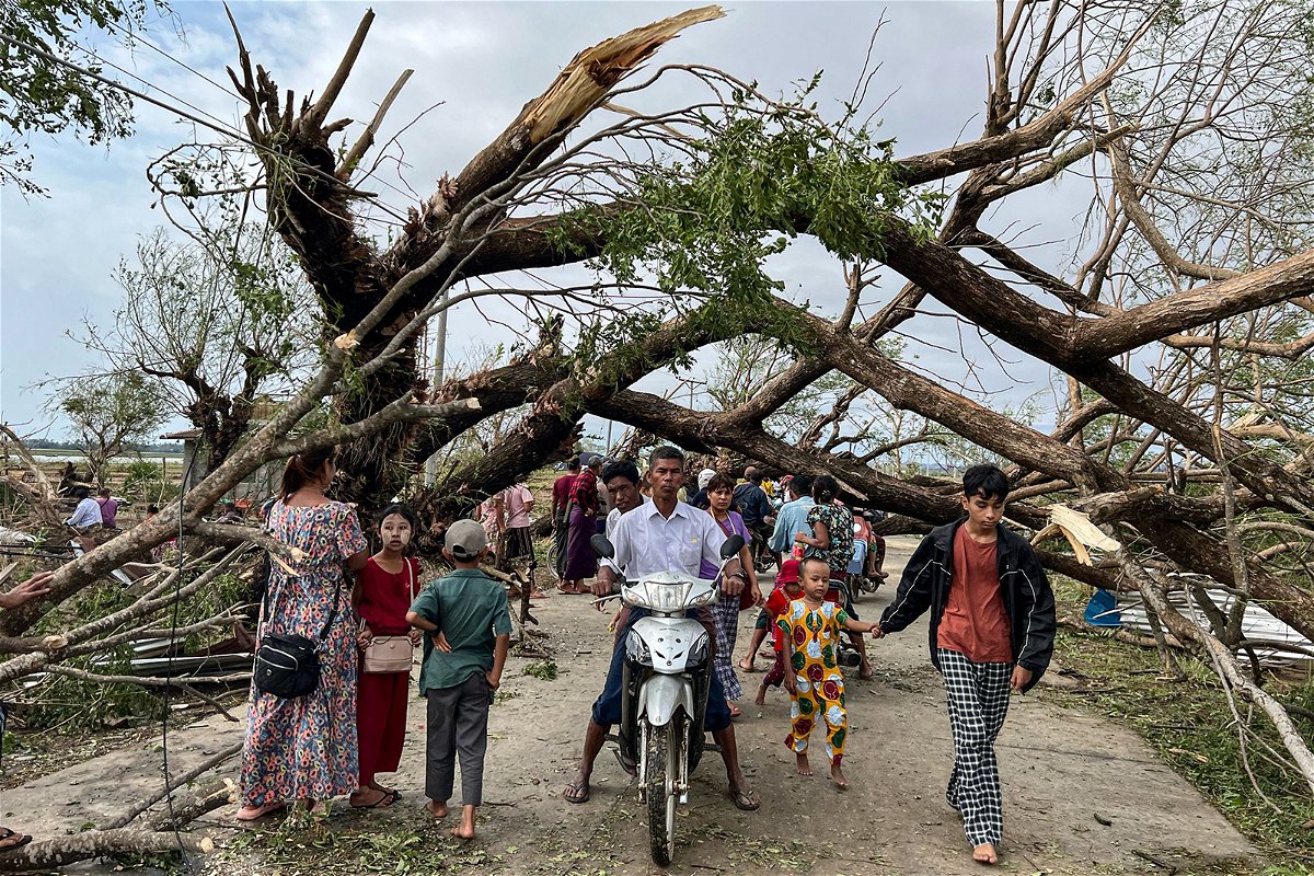 <i>Sai Aung Main/AFP/Getty Images</i><br/>Residents walk past fallen trees in Kyauktaw in Myanmar's Rakhine state on May 15