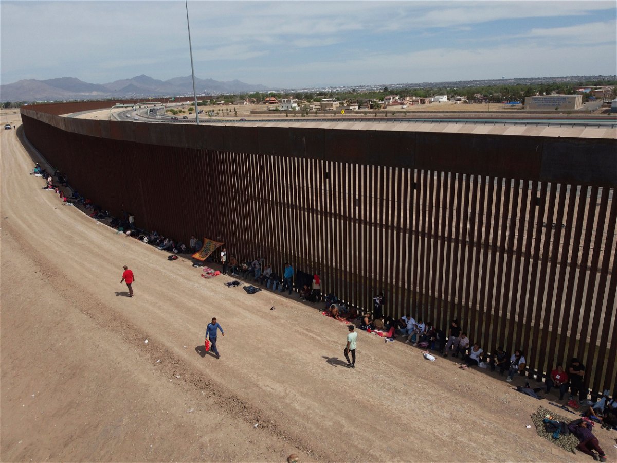 <i>Christian Chavez/AP</i><br/>Migrants camp out next to the border barrier between El Paso